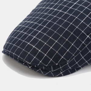Gros plan sur la casquette plate à carreaux bleus montrant la texture et les coutures