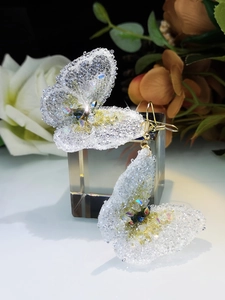 Detail of handcrafted crystal butterfly earrings with sparkling beads and gold hooks