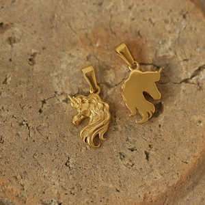 Macro shot of gold-plated unicorn pendants on stone, showing vintage sun god engraving details