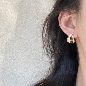 Elegant gold drop earrings with brown tiger eye stones and zircon worn by a model
