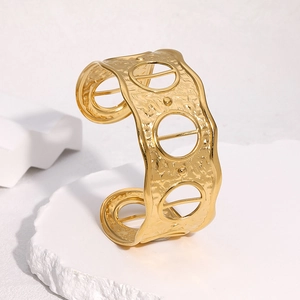 Detail of 18k gold open bangle with hammered texture and geometric hollow design