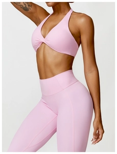 Detail of pink yoga set featuring a twisted halter sports bra and high-waisted leggings