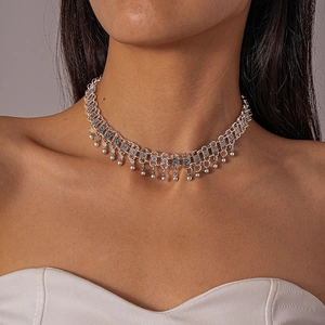 Detail of silver vintage choker with hollow square patterns and small bead charms