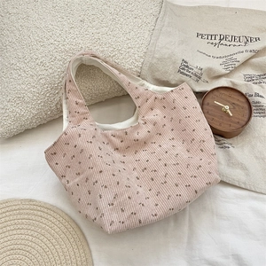Close-up of pink corduroy tote bag with floral print and soft fabric texture detail
