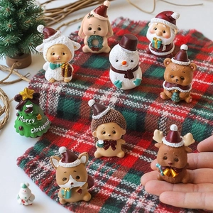 Miniature Christmas figurines set with Santa Claus and animals on plaid background