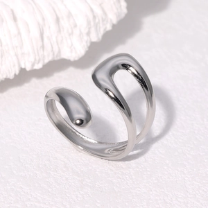 Artistic silver open ring with streamlined organic design on white stone background