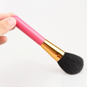 Detail der weichen schwarzen Borsten und des rosa Griffs eines Puder-Make-up-Pinsels
