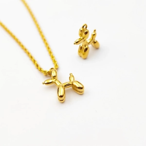 Polished 18K gold balloon dog pendant necklace and charm set on white background