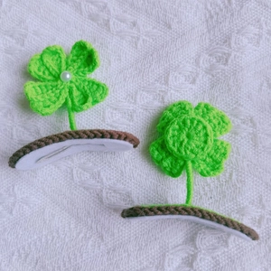Detailed view of handmade crochet green sprout hair clips with a white faux pearl