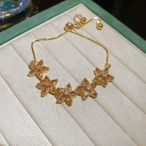 Detailed close-up of sparkling zircon flower bracelet with adjustable gold chain