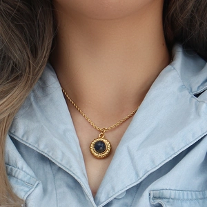Collier vintage plaqué or 18K avec pendentif en agate bleu foncé porté par mannequin