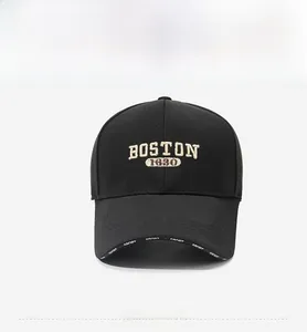 Detail of embroidered BOSTON logo and SPORT text on brim of black baseball cap