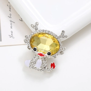 Detailed view of baby dragon charm with yellow gemstone and white rhinestones