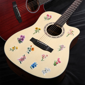 Detailed view of colorful floral PET stickers decorating a light wood acoustic guitar body