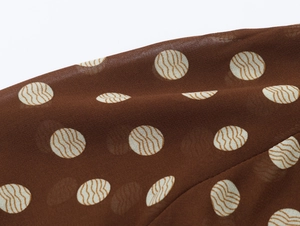 Vue macro détaillée du tissu en mousseline marron semi-transparent à motif de pois fins