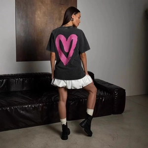 Λεπτομέρεια μαύρου oversized βαμβακερού t-shirt με ροζ καρδιά τυπωμένη στην πλάτη