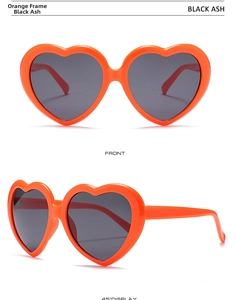 Detail of oversized orange heart-shaped sunglasses with dark grey lenses shown from two angles