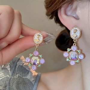 Détail de boucles d'oreilles vintage style palais avec pierres roses et camée sculpté