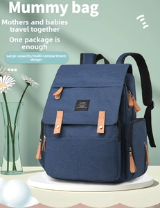 Detailed view of deep blue diaper bag with brown leather accents and multi-layer storage
