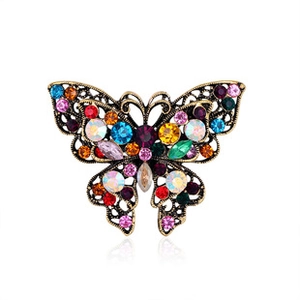 Detail of vintage bronze butterfly brooch with colorful rhinestones on white background