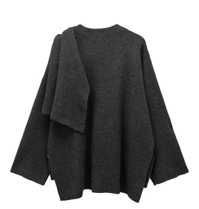 Detail view of dark grey knitted fabric texture and asymmetric draped hem design