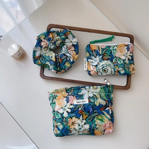 Detailed set of floral print storage bags and scrunchie on a wooden tray decor