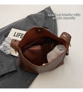Spacious interior of a dark brown woven tote bag showing daily essentials and inner pouch