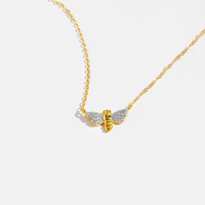 Detailed close-up of a golden bee pendant necklace with sparkling white cubic zirconia