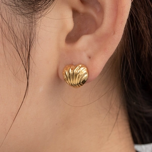 Boucles d'oreilles cœur dorées de luxe français avec texture gouttes sur mannequin