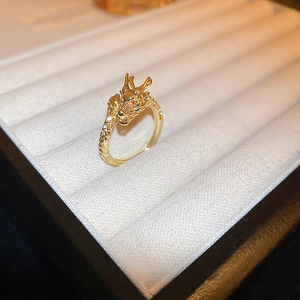 Macro view of gold dragon ring with red gem eyes and white zircon inlay in a velvet box