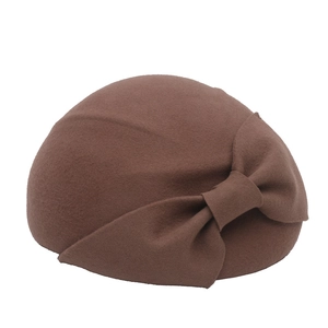 Close-up of brown wool felt beret featuring a vintage bow detail and elegant texture