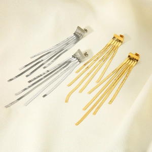 Detail of 18k gold plated stainless steel long tassel earrings on silk background