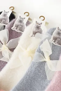 Detailed close-up of fluffy rabbit velvet socks with organza bows and soft plush texture