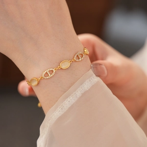 Détail d'un bracelet nez de cochon doré serti de diamants et pierre œil de chat