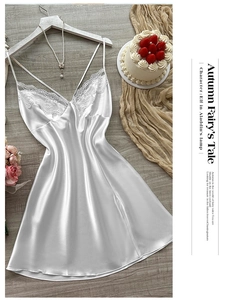Detail of white satin sleepwear featuring delicate lace trim and elegant pearl sheen texture
