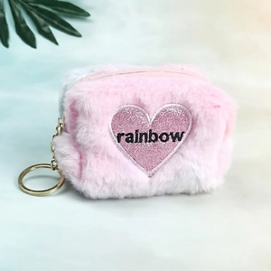 Detail of pink plush heart coin purse with rainbow embroidery and golden keychain
