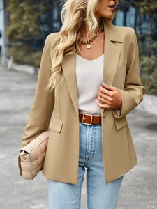 Detail of short-sleeve blazer lapel and button closure in khaki street style fashion