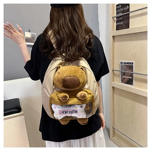 Detail of beige nylon backpack with 3D capybara plush and transparent PVC window