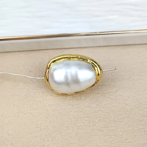 Macro shot of an irregular baroque pearl bead with elegant gold plated edging detail