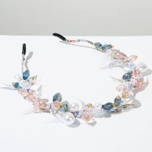 Dettaglio del cerchietto floreale con cristalli blu e decorazioni di perle bianche