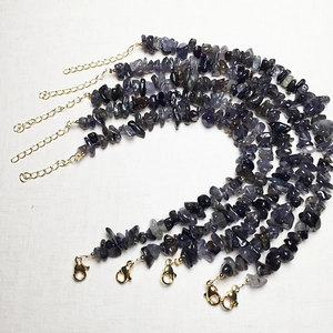 Detailed view of five natural iolite chip bead bracelets with golden lobster clasps