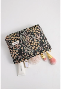 Detailed close-up of a floral jacquard makeup bag with elegant embroidery and white brand tag