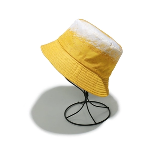 Cappello a secchiello sfumato giallo con bolle di birra su supporto in metallo