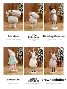 Collection of wool felt Christmas reindeer and snowman decorations on wooden texture
