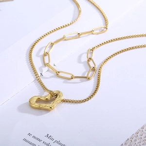 Golden double layer necklace featuring a heart pendant and paperclip chain design