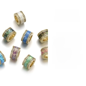 Macro detail of planet charms with colorful enamel inlay and sparkling zircon settings