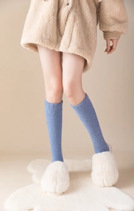 Blue coral fleece over-the-knee socks for women styled with plush slippers in home setting