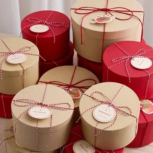 Eco-friendly round kraft paper gift boxes with red lids and decorative twine bows