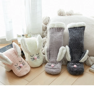 Close-up of fluffy winter socks with rabbit ears in pink, white, and grey tones