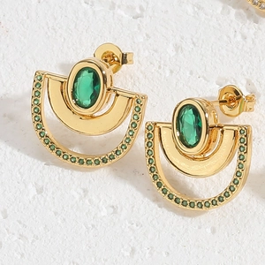 Close-up of gold stud earring with oval green gemstone and semi-circle zircon detail